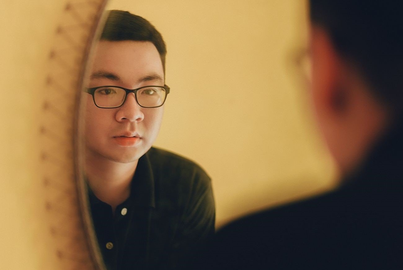 A person starring in the mirror pondering on self