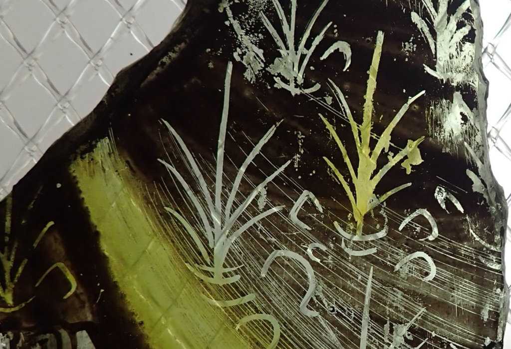 Fragment of predominantly yellow and black mid fifteenth century stained glass from St Michael's (Coventry's second Cathedral) showing foliage and on the left, the top of a shroud, pleated fabric tied together.