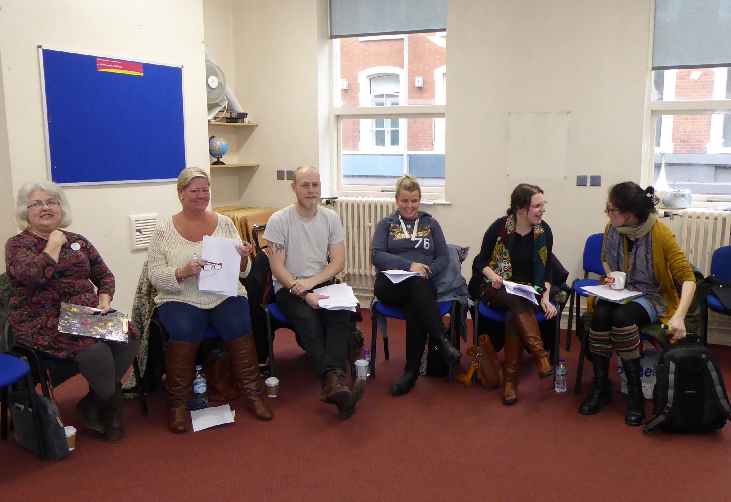 students sitting in a semi circle smiling 